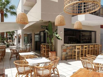 Jasny teren zewnętrzny hotelu z meblami bambusowymi i przytulną atmosferą.