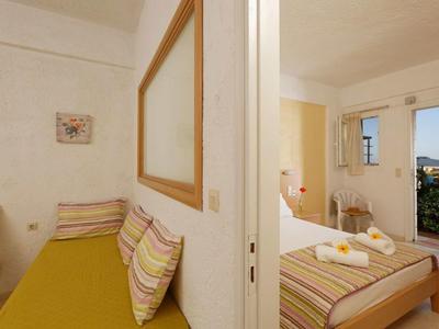 Stanza divisa con camera da letto accogliente e area salotto dai colori caldi.