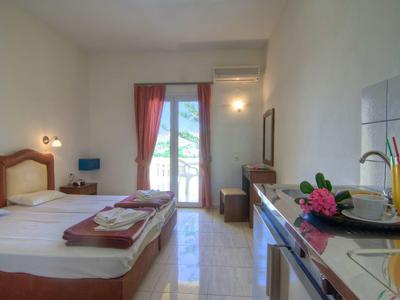 Ein helles Hotelzimmer mit zwei Betten, Balkon und einem Tisch mit Frühstück.