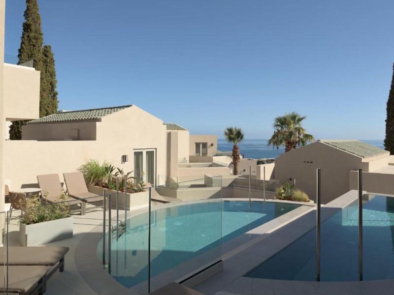 Área de piscina exterior moderna con vista al mar y vegetación mediterránea