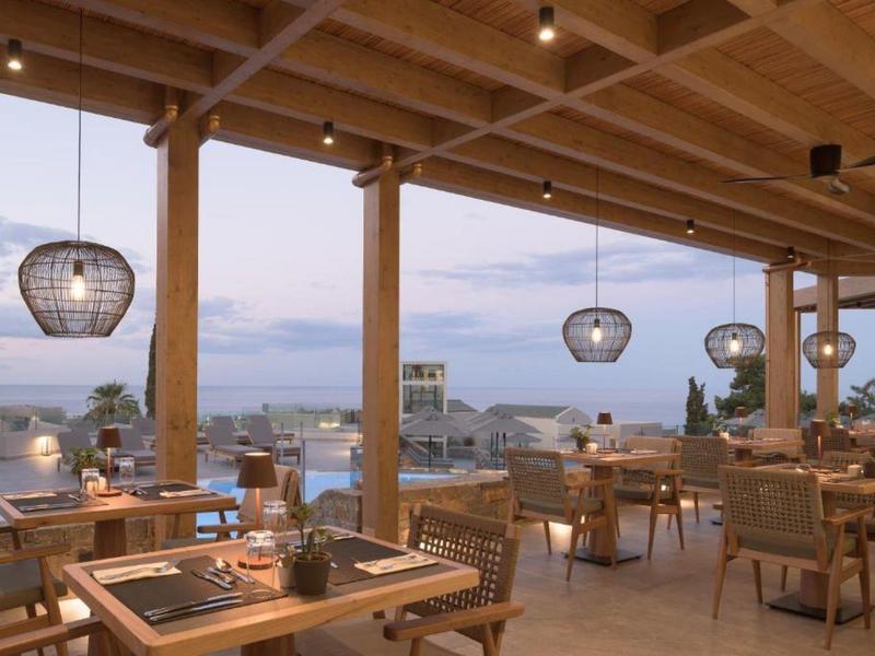 Área de comedor abierta con luces modernas y vista a la ciudad al atardecer