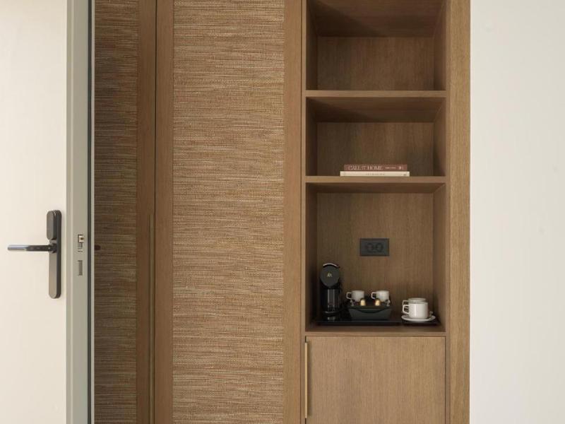 Armario de madera clara con compartimento incorporado para cafetera y puerta abierta