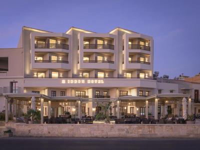 Hotel moderno con balcones iluminados y terraza al anochecer
