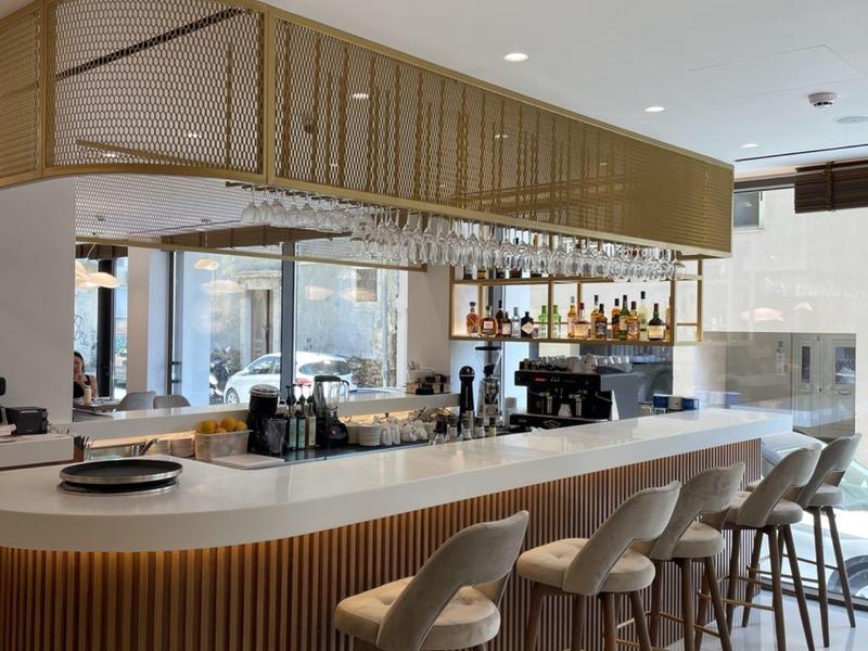 Area bar moderna in hotel con bancone curvo e sgabelli eleganti