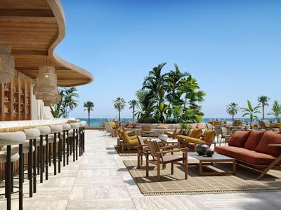 Moderner Außenbereich mit Bar und komfortablen Sitzgelegenheiten, Palmen und Meerblick.