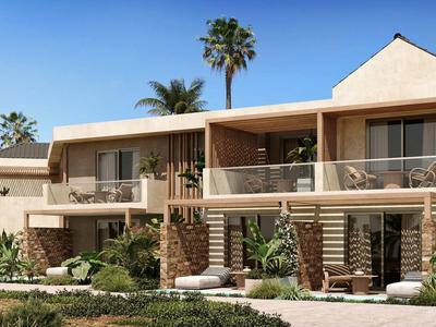 Modernes zweistöckiges Haus mit großen Glasfenstern, Balkon, Palmen und üppiger Begrünung.