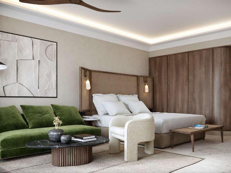 Modernes Schlafzimmer mit grauem Bett, grünem Sofa, Holzvertäfelung und abstraktem Wandbild.