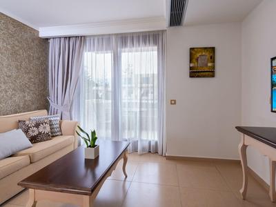 Modern eingerichtetes Wohnzimmer mit Sofa, Couchtisch und großem Fenster mit Vorhängen.
