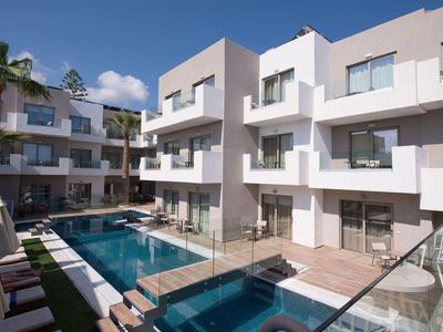 Moderne Hotelanlage mit drei Etagen, Pool und Terrassen bei sonnigem Wetter.