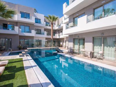Moderner Hotelpool mit Liegestühlen und Palmen unter klarem blauem Himmel.