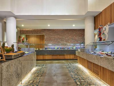 Espace buffet moderne avec surfaces en marbre, accents en bois et éclairage indirect.