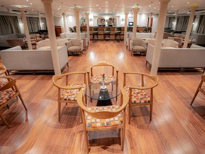 Eleganter Lounge-Bereich mit Holzboden und komfortablen Sitzen in warmem Licht.