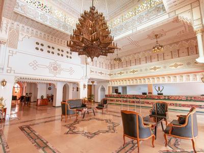 Eleganckie wnętrze lobby hotelowego z dużymi żyrandolami i stylowymi miejscami do siedzenia.