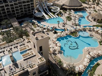 Vista aerea di un grande hotel con diverse piscine e scivoli d'acqua.