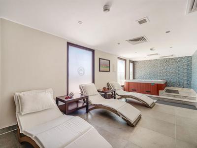 Area benessere moderna con lettini e vasca idromassaggio in un ambiente tranquillo