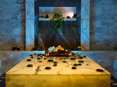 Mesa de mármol con velas encendidas en un ambiente acogedor de spa o baño turco.