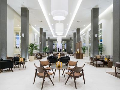Großzügiger Hotel-Loungebereich mit modernen Möbeln und heller Beleuchtung.