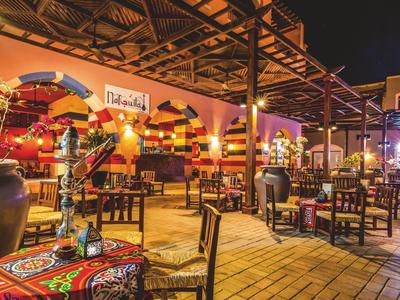 Cozy outdoor restaurant with colorful decorations and wooden chairs at night.