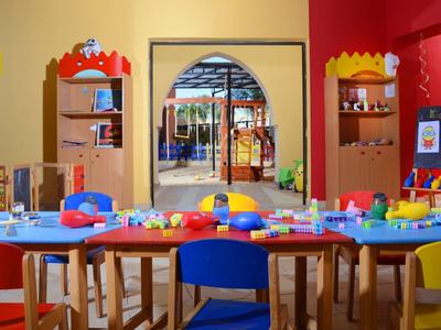 Colorful kids' play area with tables, chairs, and toys in front of an exit.