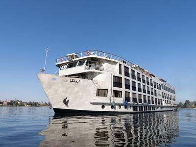 Grande nave da crociera bianca su acqua calma sotto un cielo blu limpido.