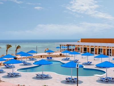 Moderner Hotelpool mit blauen Sonnenschirmen und Blick auf das Meer bei Sonnenschein.