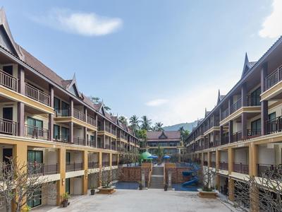 Großes, symmetrisches Wohnkomplex mit drei Etagen, braunen Balkonen und hellgelben Fassaden.