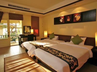 Modernes Hotelzimmer mit zwei Betten, Schreibtisch, Lampen und Balkon mit Blick nach draußen.