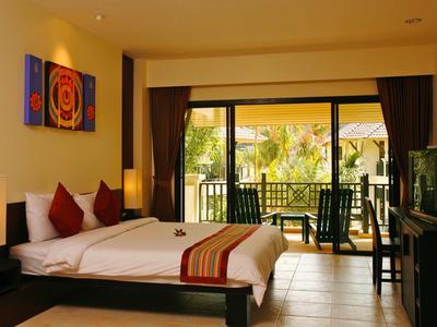 Helles Hotelzimmer mit Doppelbett, Balkon und tropischer Aussicht.