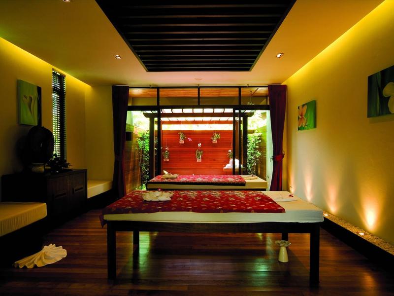 Gemütliches Schlafzimmer mit Holzboden, warmem Licht und rotem Bett im asiatischen Stil.