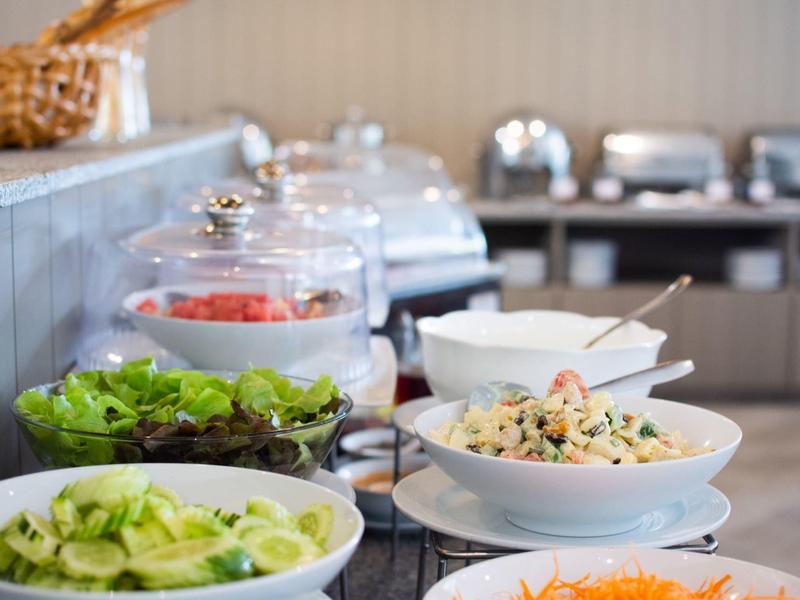 Buffet met verschillende salades en dressings in een hotelkeuken