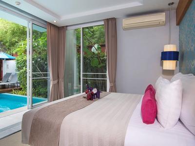 Modernes Schlafzimmer mit großem Bett, hellen Kissen und Blick auf Außenpool und Garten durch GlasschiebeTür.