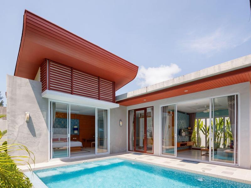 Modernes Haus mit großem Pool, glatten Wänden und risiger, abgeschrägter Dachkonstruktion.