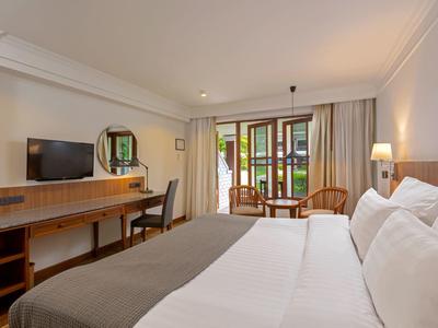 Modern eingerichtetes Hotelzimmer mit Doppelbett und Balkon mit Blick ins Grüne.