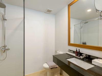 Modernes Badezimmer mit Glasduschwand, Waschbecken und großem Spiegel.