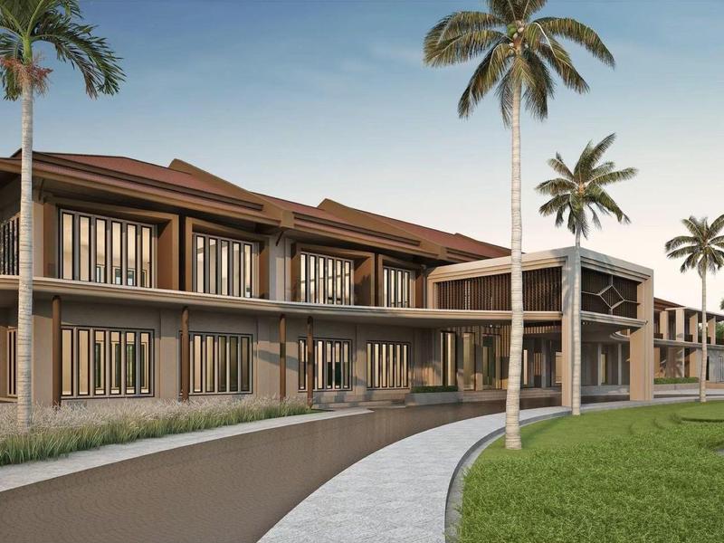 Modern hotel building with palm trees and paved paths in a tropical setting.