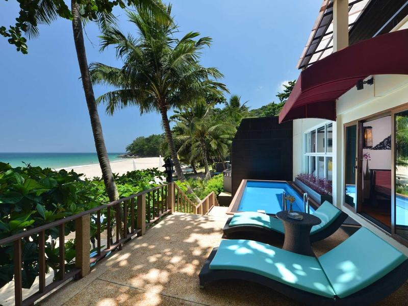 Terrace with loungers and private pool, sea view and palm trees by the beach.