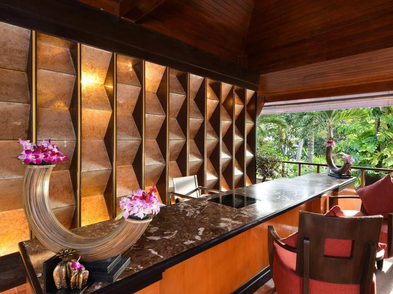 Elegant hotel reception with wood paneling, marble counter, and floral decor.
