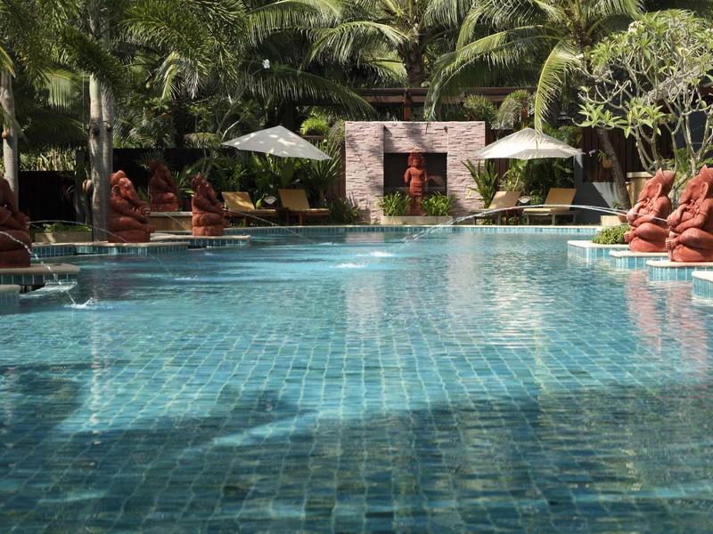 Inviting pool surrounded by statues and lush greenery at a hotel resort.