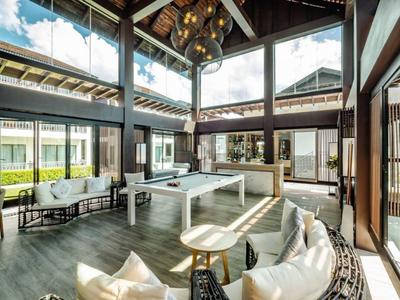 Ein heller Wohnbereich mit großen Fenstern, modernen Möbeln und reichlich natürlichem Licht.