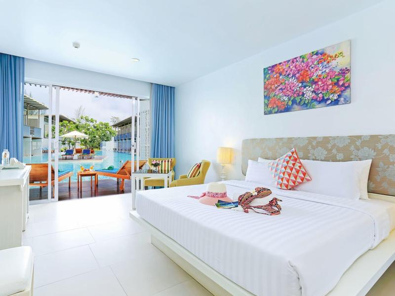 Helles Hotelzimmer mit Doppelbett, blauem Vorhang und Balkon mit Blick auf Pool und Garten