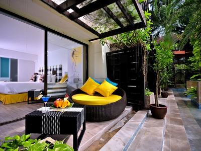 Moderner Außenbereich mit runden Sitzmöbeln, gelben Kissen, Glasdach und angrenzendem Schlafzimmer.