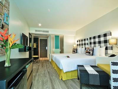 Modernes Hotelzimmer mit Doppelbett, buntem Vogelblumenstrauß und Holzfußboden.