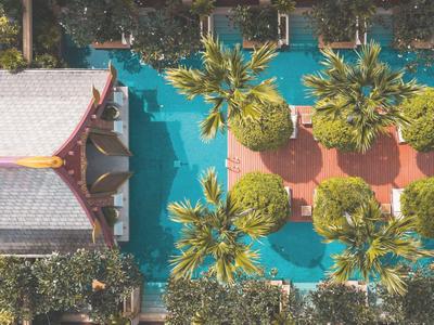 Widok z lotu ptaka hotelu z basenem i tropikalnym ogrodem z palmami i miejscami do siedzenia.