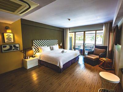 Modern eingerichtetes Hotelzimmer mit großem Bett, Balkonzugang und gemütlicher Sitzecke.