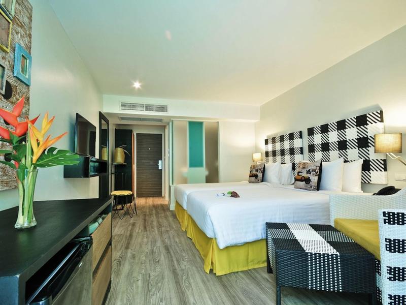 Modernes Hotelzimmer mit Doppelbett, buntem Vogelblumenstrauß und Holzfußboden.