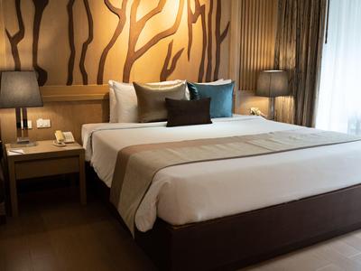 Modernes Hotelzimmer mit großem Doppelbett, dekorativer Wand und stimmungsvoller Beleuchtung.