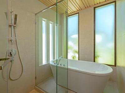 Modernes Badezimmer mit freistehender Badewanne und Dusche neben großen Fenstern.