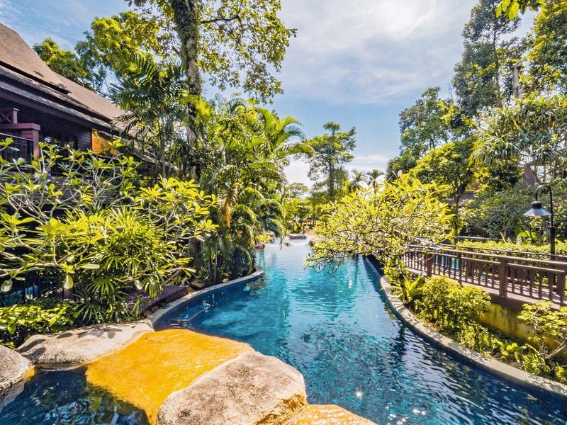 Ein malerischer Poolbereich umgeben von üppigem Grün und Natur im Außenbereich eines Hotels.