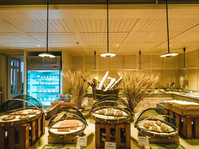 Buffet mit Brot und Backwaren in einem gemütlichen Restaurant mit warmem Licht.