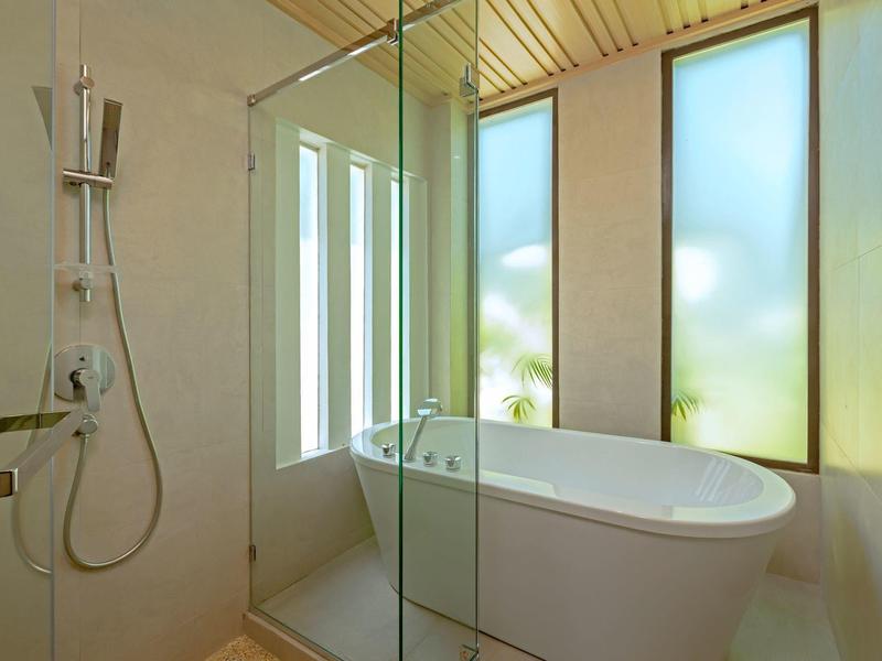 Modernes Badezimmer mit freistehender Badewanne und Dusche neben großen Fenstern.